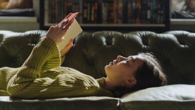 woman in yellow long sleeve shirt lying on couch